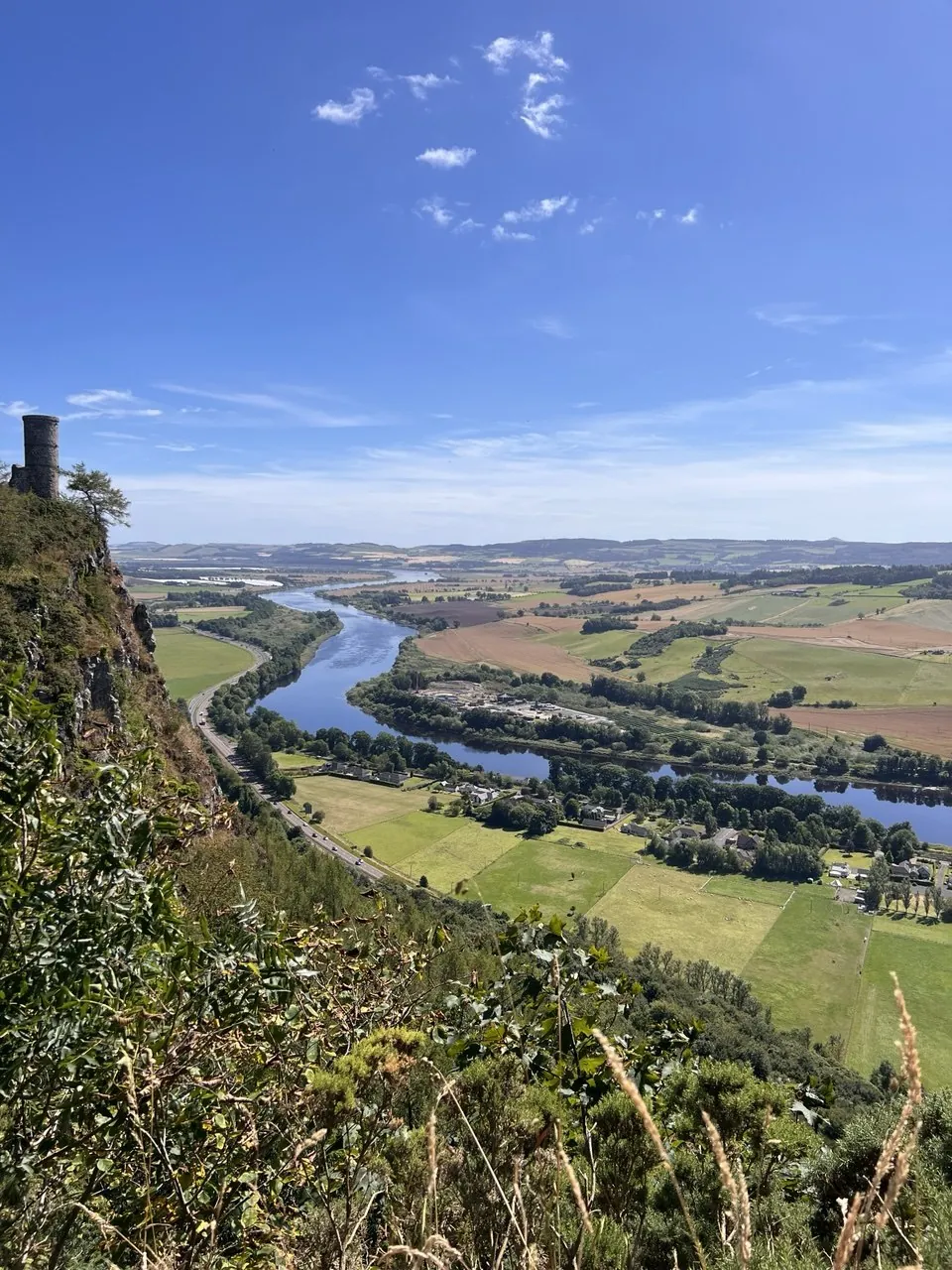 Looking east from the cliff on Kinnoull Hill over the River Tay and the Carse of Gowrie, with Kinnoull Tower standing on the edge of the crag